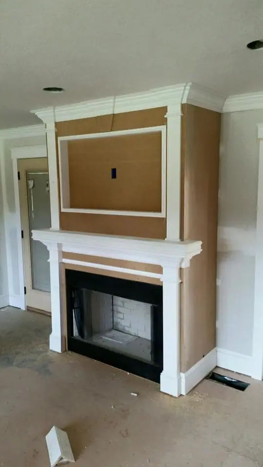 A white fireplace surround and mantel, trim complete