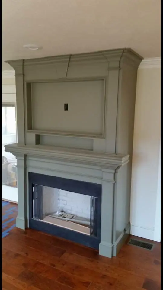 A painted green-grey fireplace surround and overmantel
