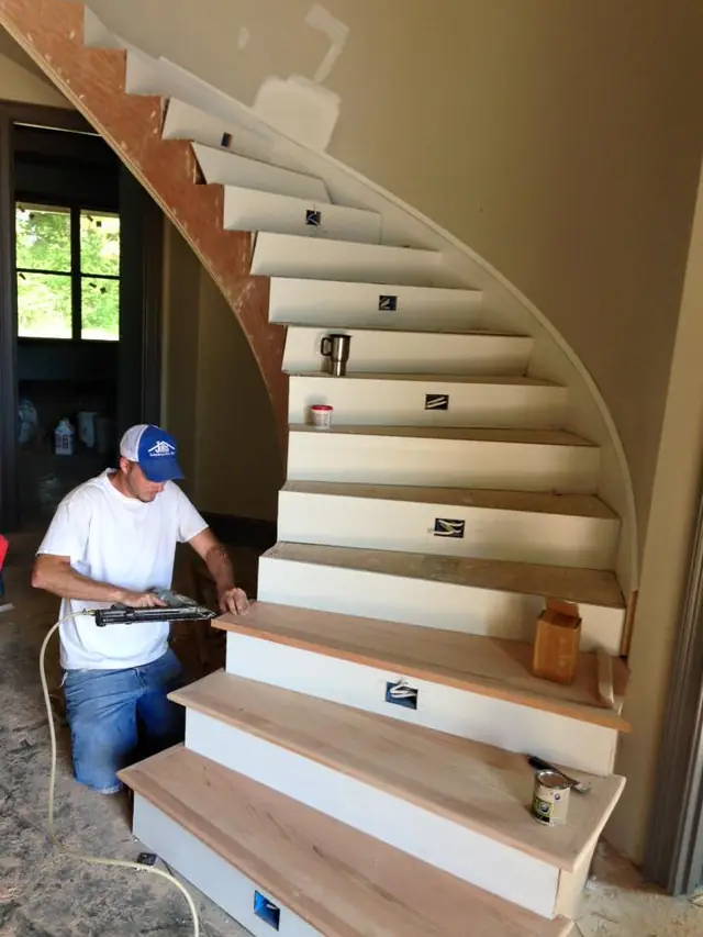 A carpenter fitting open curved-stair treads