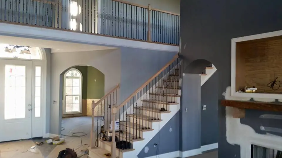 An open foyer staircase with a balcony rail above